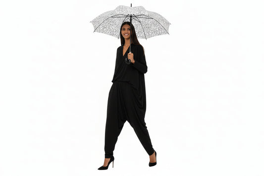 Woman holding a patterned umbrella wearing a matching outfit on a white background