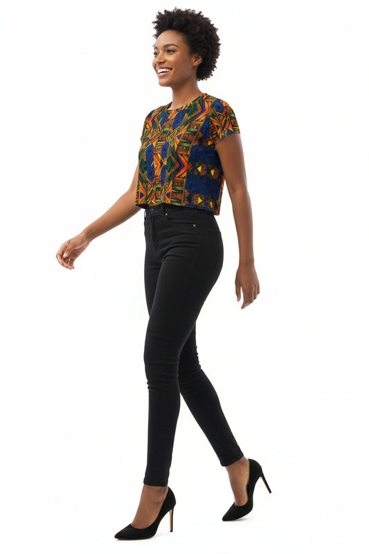 Woman wearing a colorful top and denim shorts on a white background