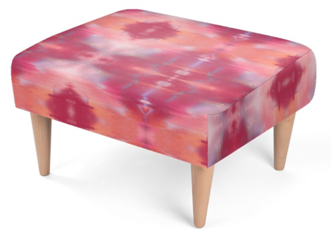 A square footstool with a vibrant pink, red, and orange tie-dye patterned fabric upholstery and four tapered light wood legs, shown on a plain white background.