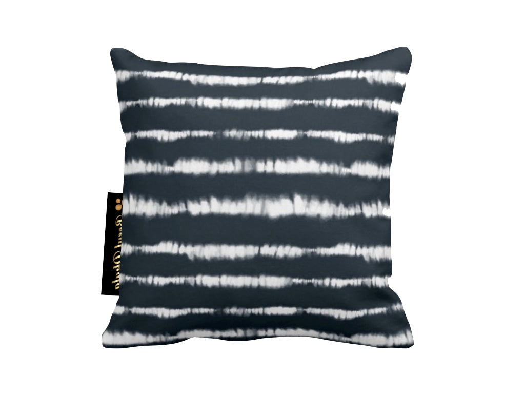 Navy and white tie-dye patterned pillow with a brand label on a white background