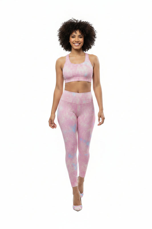 Woman wearing a KhuKhuZ pink tie-dye sports bra and leggings set on a white background
