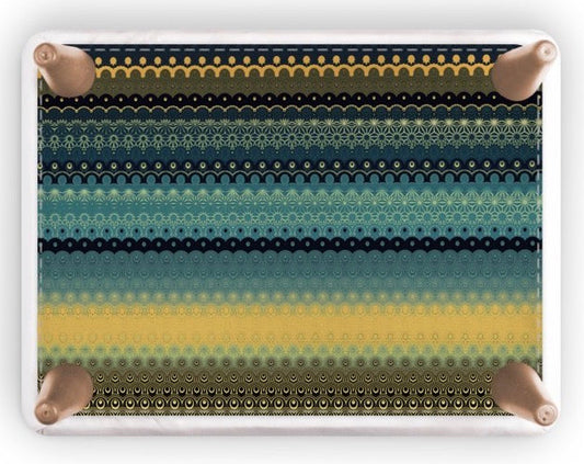 A rectangular footstool with rounded corners, featuring a horizontal striped pattern of black, teal, and yellow halftone dots, shown on a white background with a soft drop shadow.