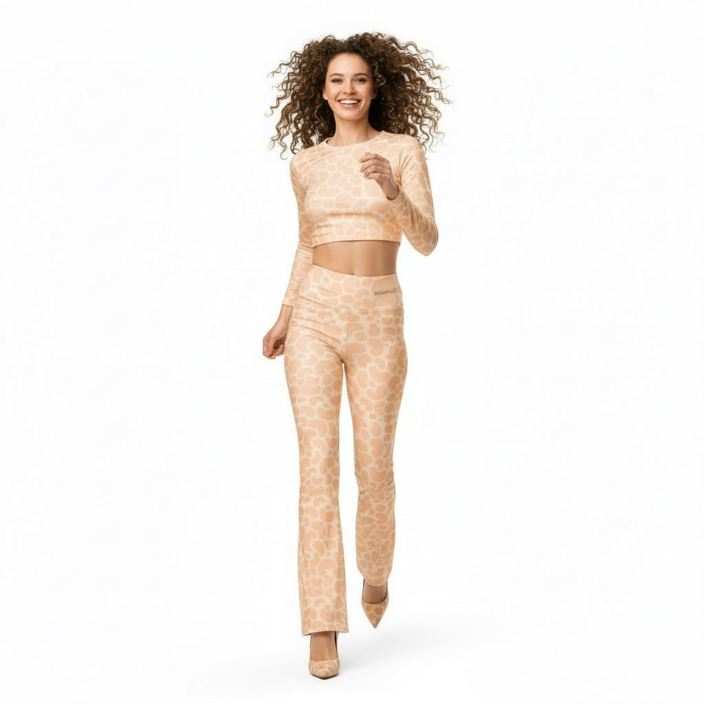 Woman wearing a black sleeveless top and patterned pants on a white background