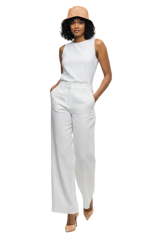 Woman wearing a patterned jumpsuit and hat on a white background