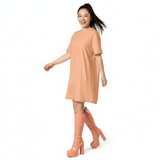 Woman wearing a peach dress and matching knee-high boots on a white background