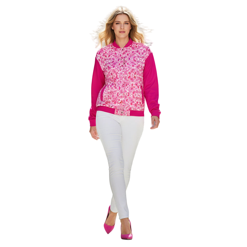 A person wearing a pink and floral unisex bomber jacket with a hood, paired with blue jeans and white sneakers.