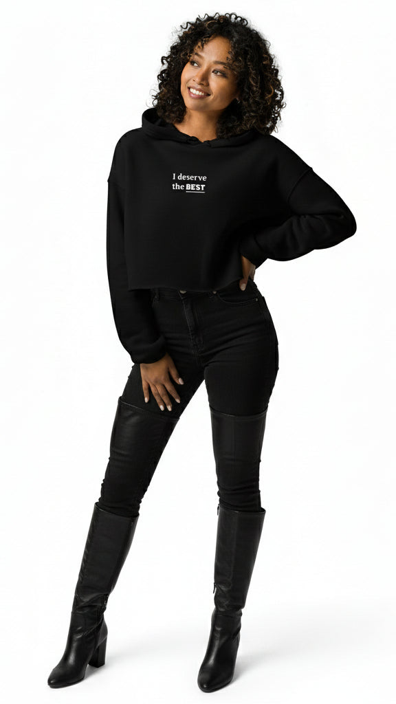 Woman wearing a black hoodie with text, black pants, and black knee-high boots on a white background
