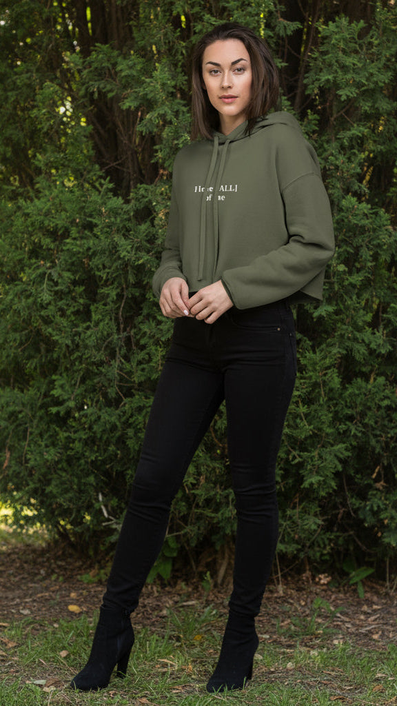 Woman wearing a green hoodie with text on a bushy background