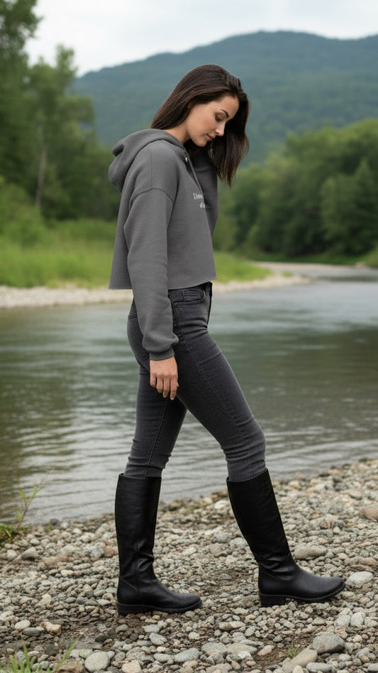 Woman wearing a gray cropped hoodie with text on it.