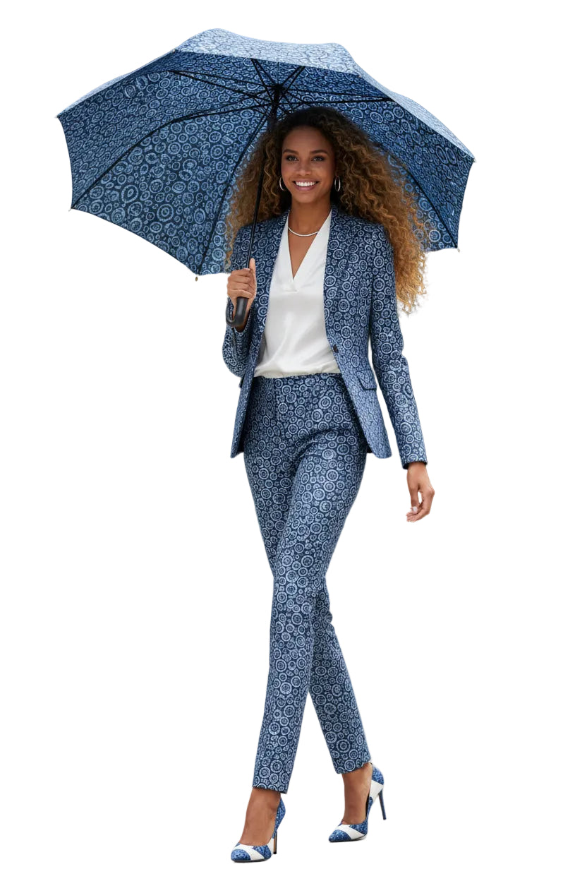 Woman in a blue patterned suit holding an umbrella on a white background