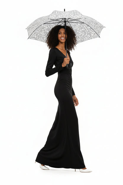 Woman holding a KhuKhuZ patterned umbrella wearing a matching outfit on a white background
