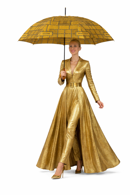 Woman in a gold dress holding a matching gold umbrella on a white background
