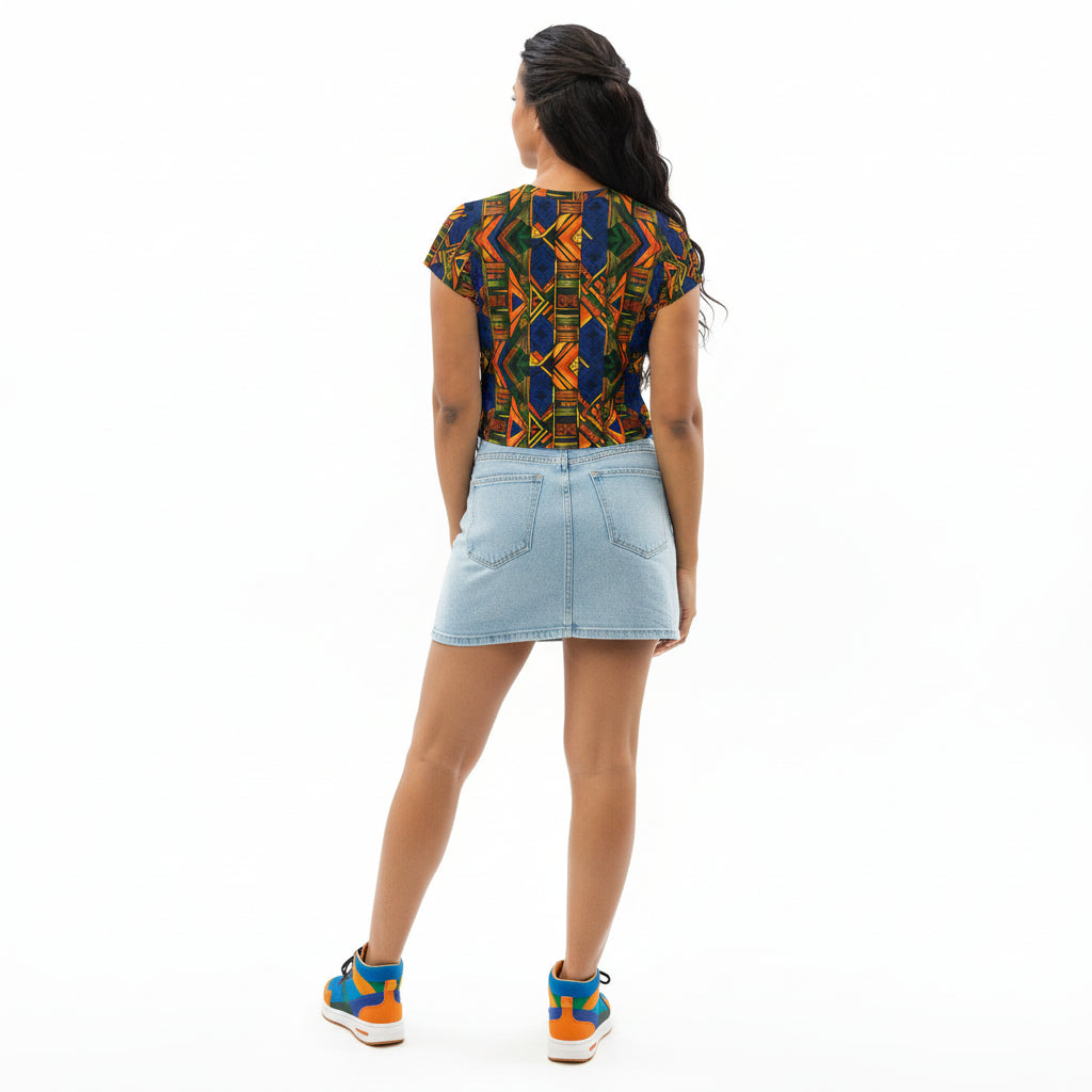 Woman wearing a colorful patterned crop top and denim skirt on a white background