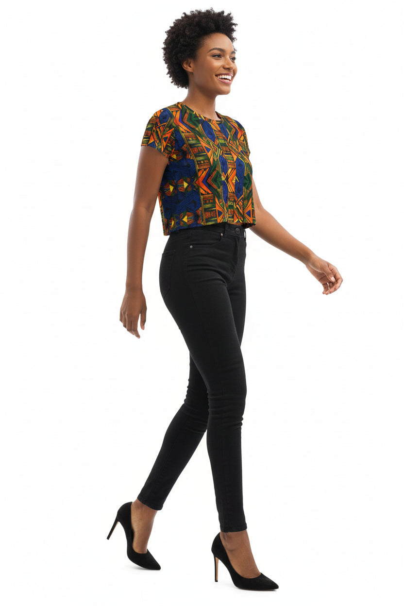 Woman wearing a colorful top and denim shorts on a white background