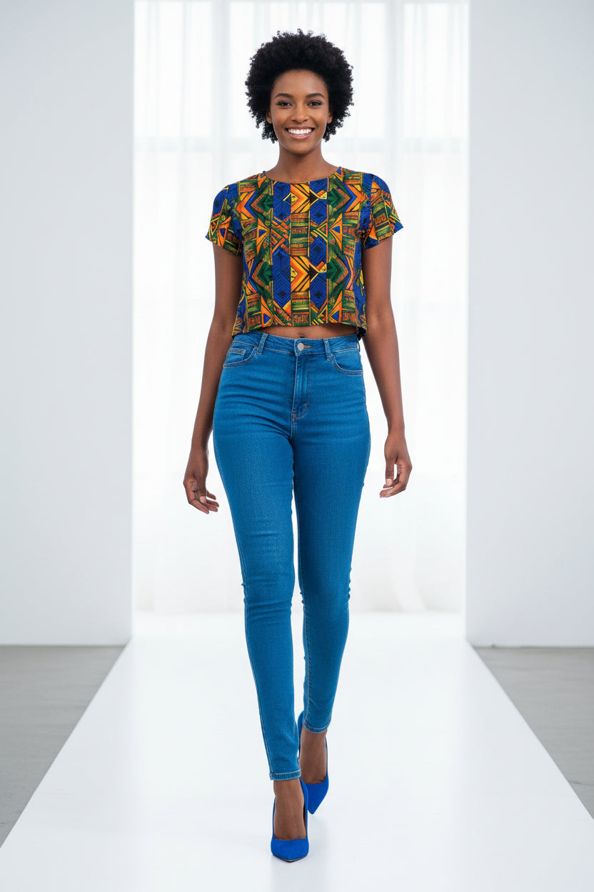 Woman wearing a colorful patterned crop top and blue jeans on a white background