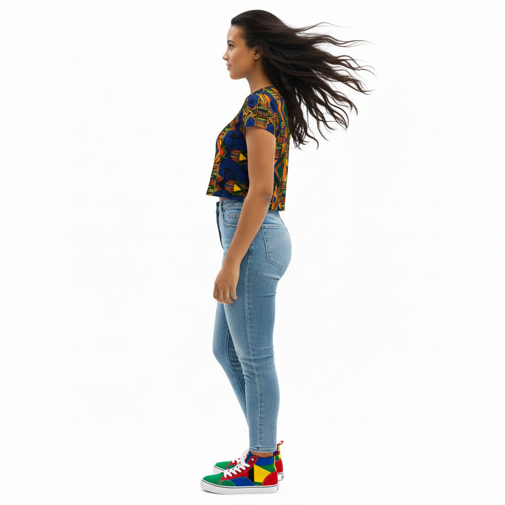 Woman wearing a colorful patterned crop top and blue jeans on a white background