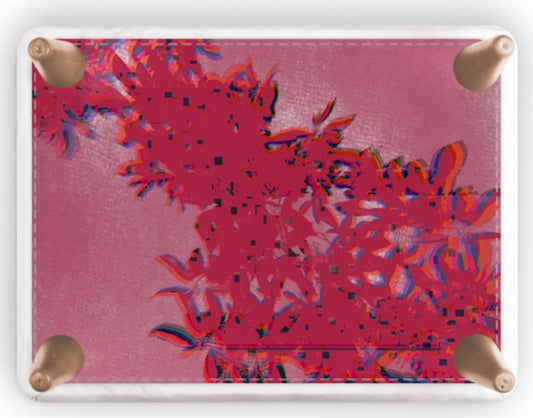 A square footstool with rounded corners and four brass grommets, featuring a vibrant pink and red abstract floral pattern printed on its surface, shown against a plain white background.