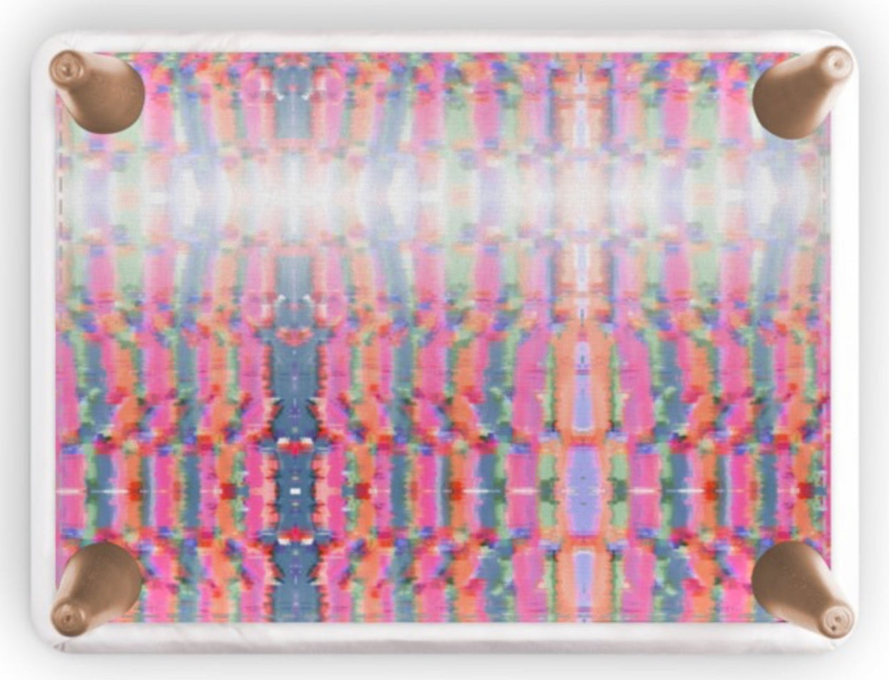 A square side table featuring a vibrant, multicolor abstract symmetrical pattern in pink, blue, green, and yellow, with four metallic rose gold corner brackets on a white background.