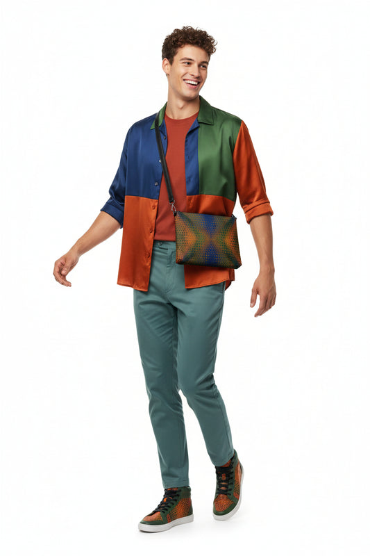 Man wearing a colorful outfit with a vest, shirt, and pants, holding a patterned khukhuz bag on a white background.