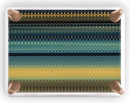 A rectangular footstool with rounded corners, featuring a horizontal striped pattern of black, teal, and yellow halftone dots, shown on a white background with a soft drop shadow.