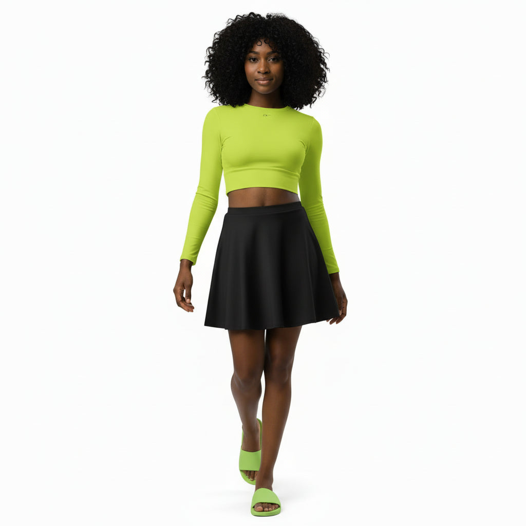 Woman wearing a bright green long-sleeve top and black skirt on a white background