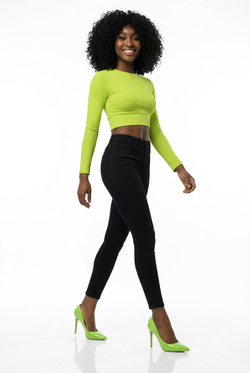 Woman wearing a bright green long-sleeve top and black skirt on a white background