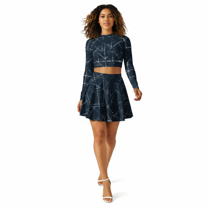 Woman wearing a navy blue long-sleeve crop top and skarter skirt set on a white background