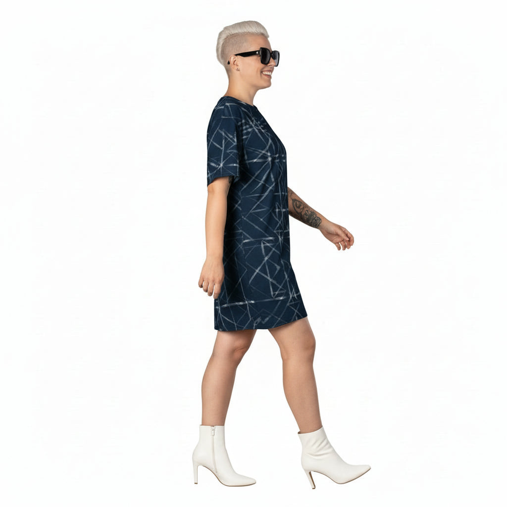 Person wearing a dark blue patterned dress with white boots on a white background