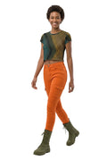 Woman wearing a patterned top and orange pants on a white background