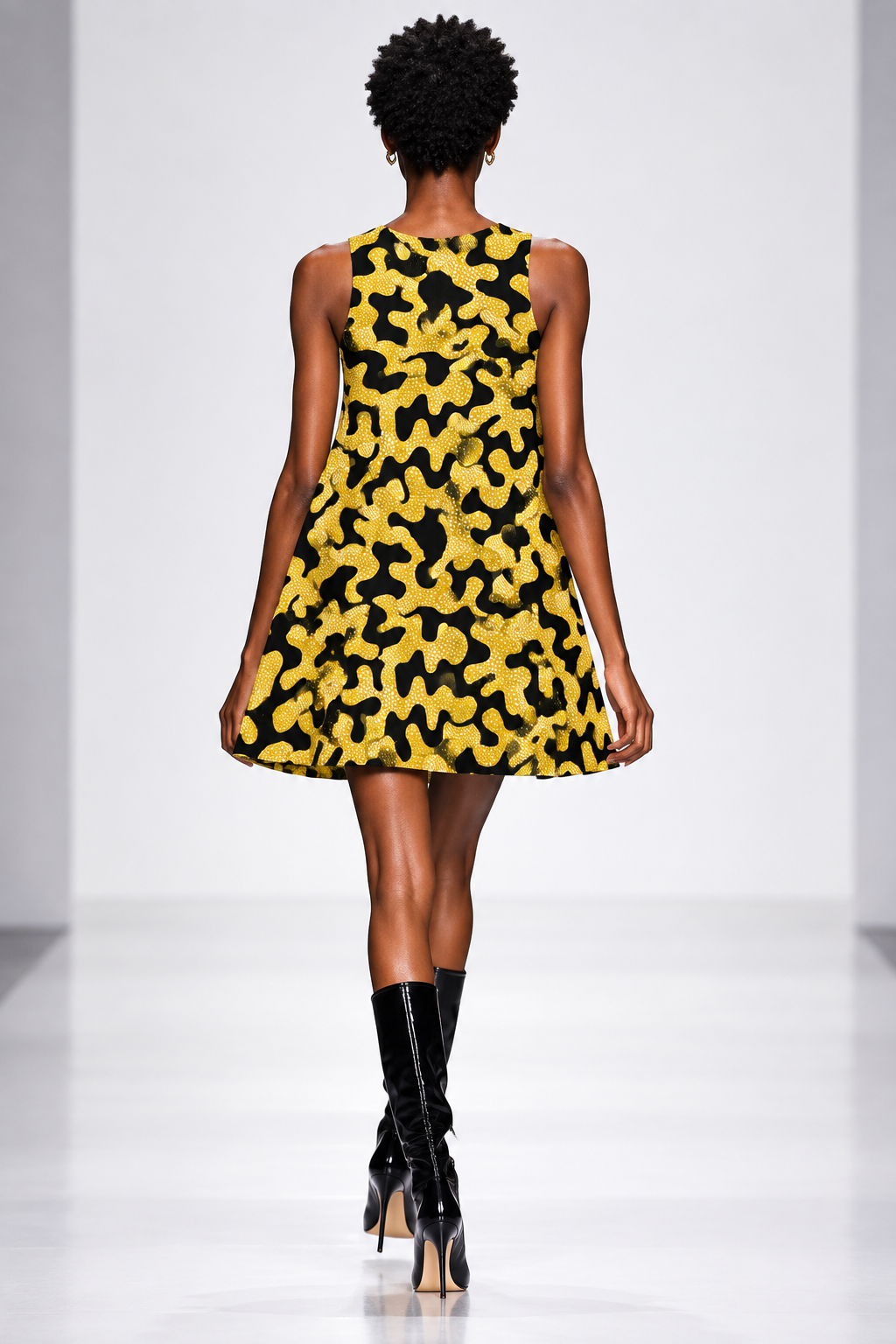 A sleeveless A-line dress with a black and mustard yellow abstract organic pattern, shown flat against a solid white background.