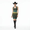 Woman wearing a patterned dress, black boots, and a cowboy hat on a white background