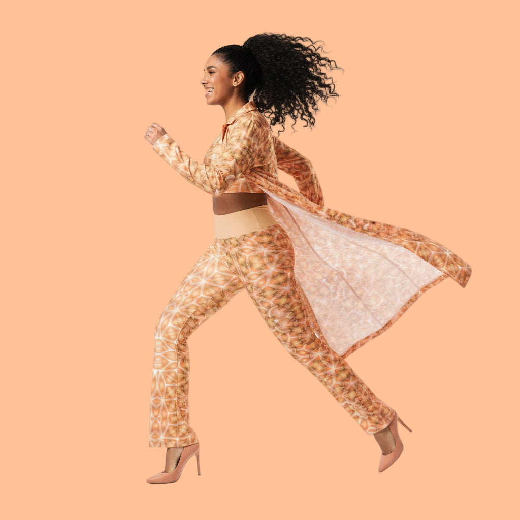 Woman wearing a peach fuzz outfit with a long coat on a white background.