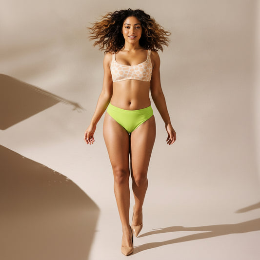 Woman wearing a neon green bikini and high heels on a neutral background