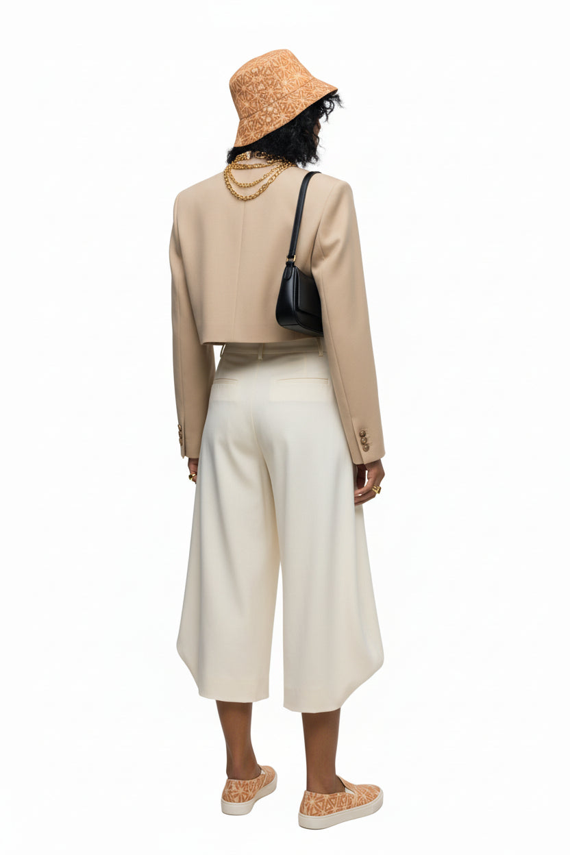 Person wearing a beige jacket, white pants, and a straw hat on a white background