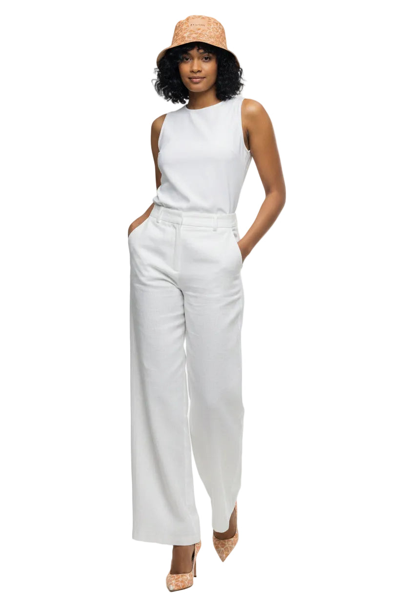 Woman wearing a patterned jumpsuit and hat on a white background