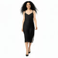 Woman wearing a black slip dress on a white background