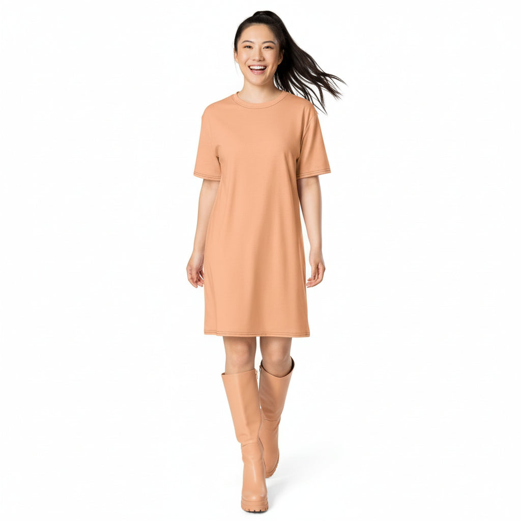 Woman wearing a peach dress and boots on a white background