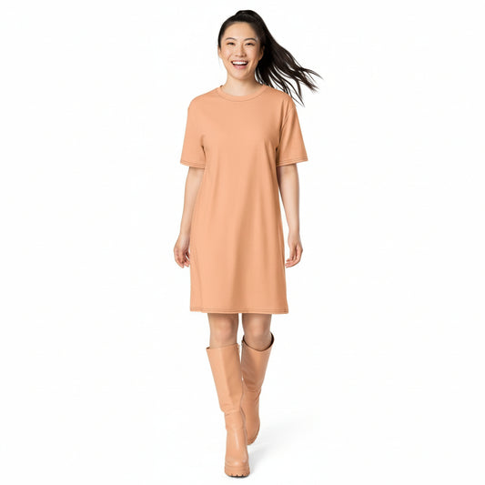 Woman wearing a peach dress and boots on a white background