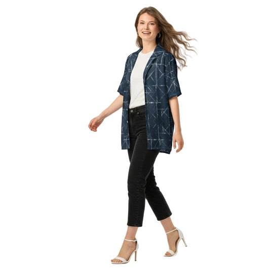 Woman wearing a blue patterned shirt over a white top with black pants on a white background