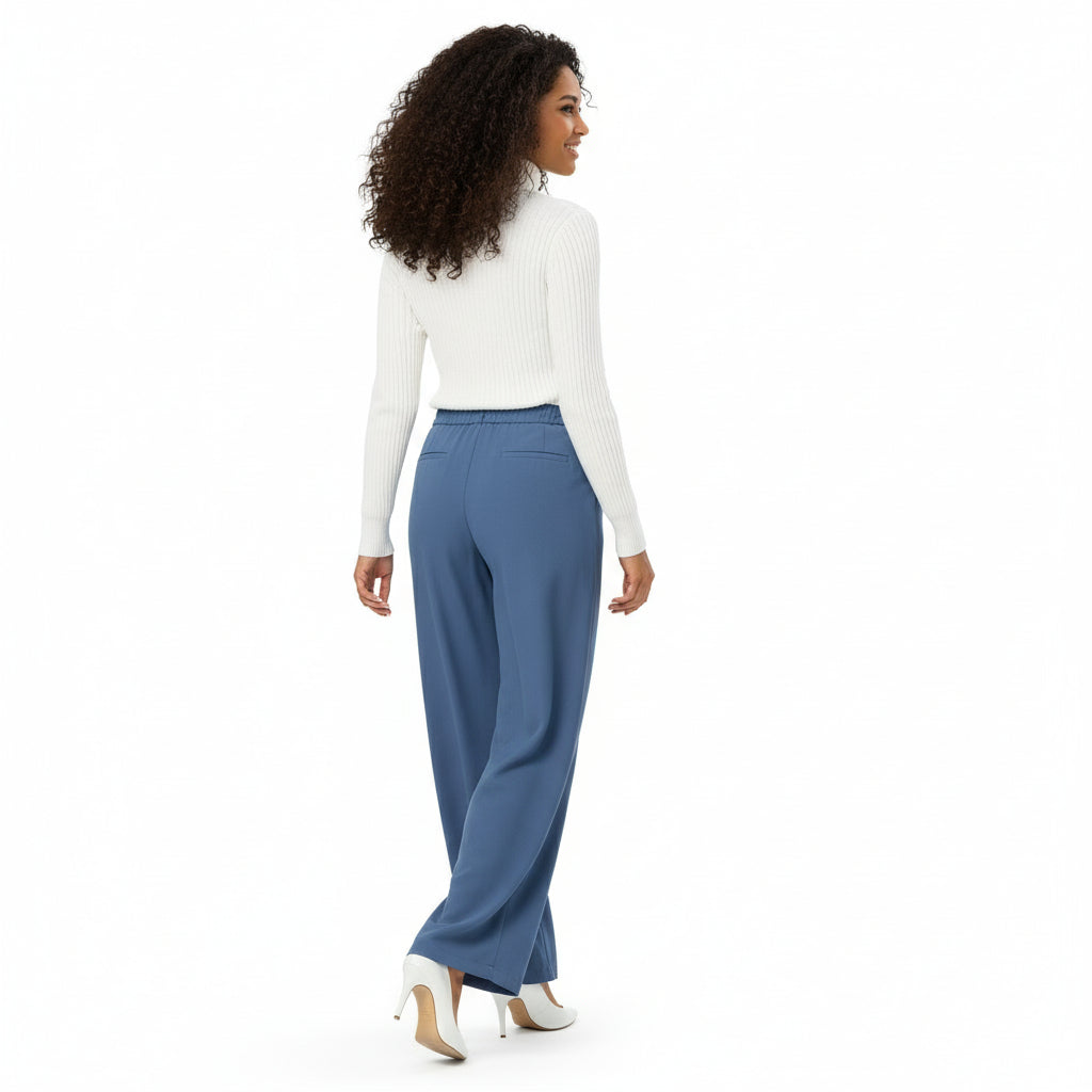 Woman wearing a white top and blue pants on a white background