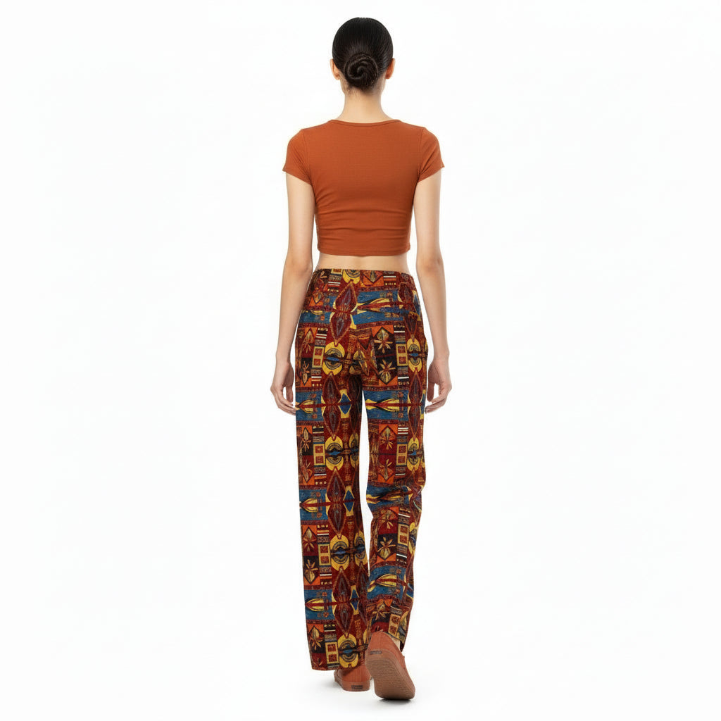 Person wearing a rusty t-shirt and colorful patterned pants on a white background