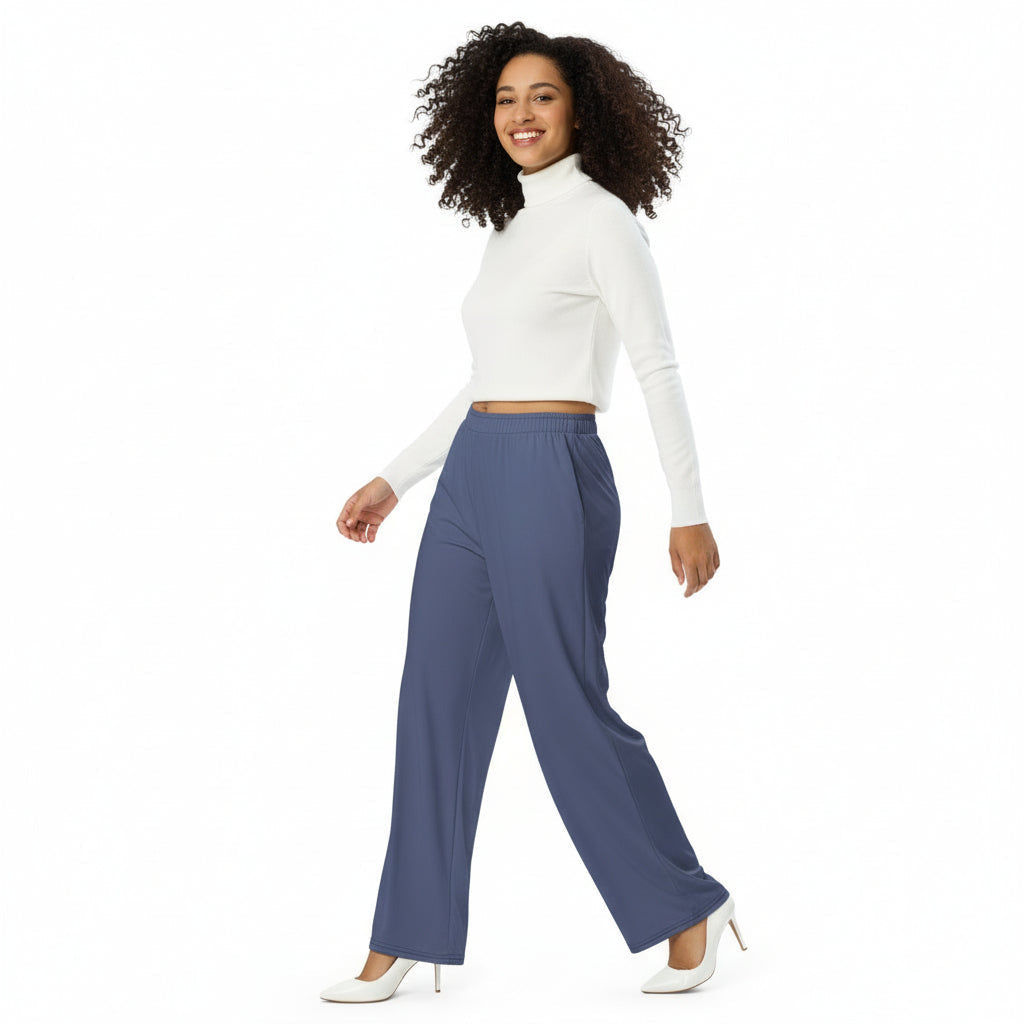 Woman wearing a white crop top and blue pants on a white background