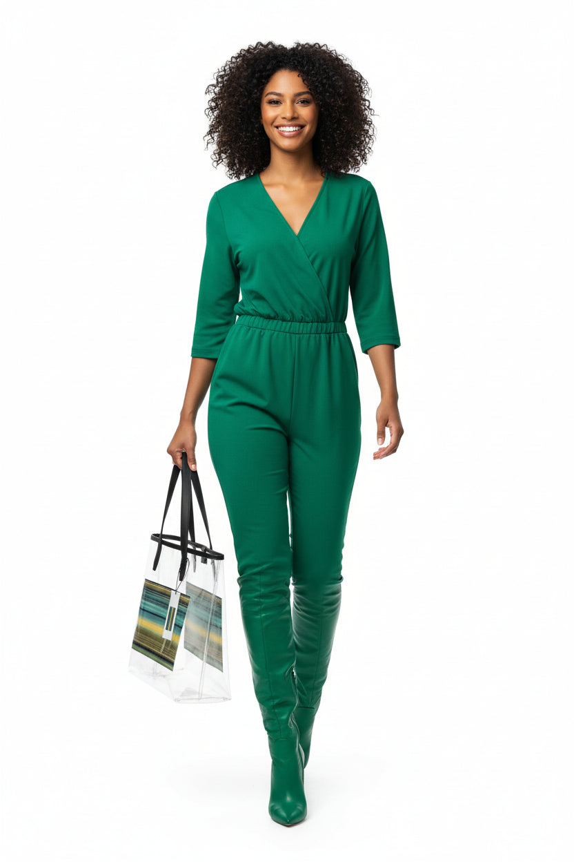Woman wearing a green jumpsuit holding a striped bag on a white background