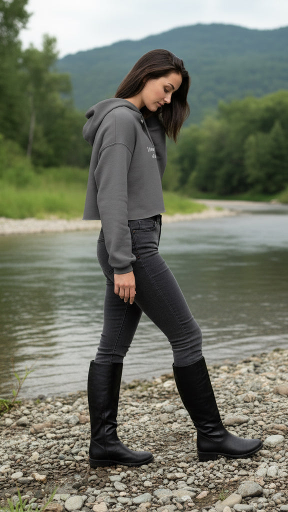 Woman wearing a gray cropped hoodie with text on it.