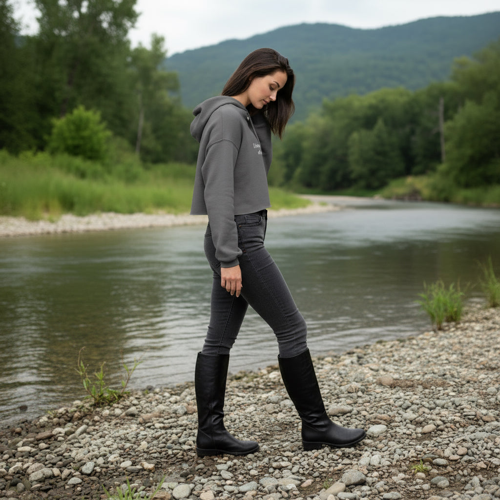 Woman wearing a gray cropped hoodie with text on it.
