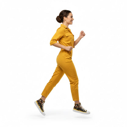 Woman in a yellow jumpsuit walking on a white background