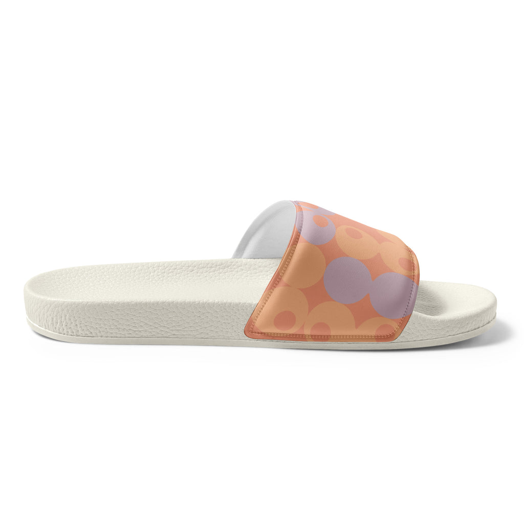 A single slide sandal with a textured off-white sole featuring a retro pattern of overlapping circles in orange, peach, and lavender, shown against a plain white background.
