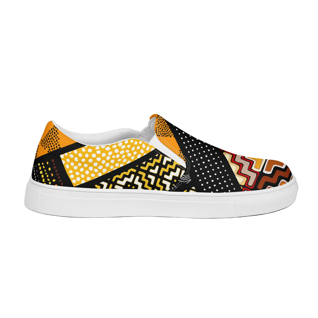 A slip-on canvas shoe featuring a vibrant, multicolor geometric and tribal-inspired print with yellow, black, white, and orange patterns, set against a clean white background.
