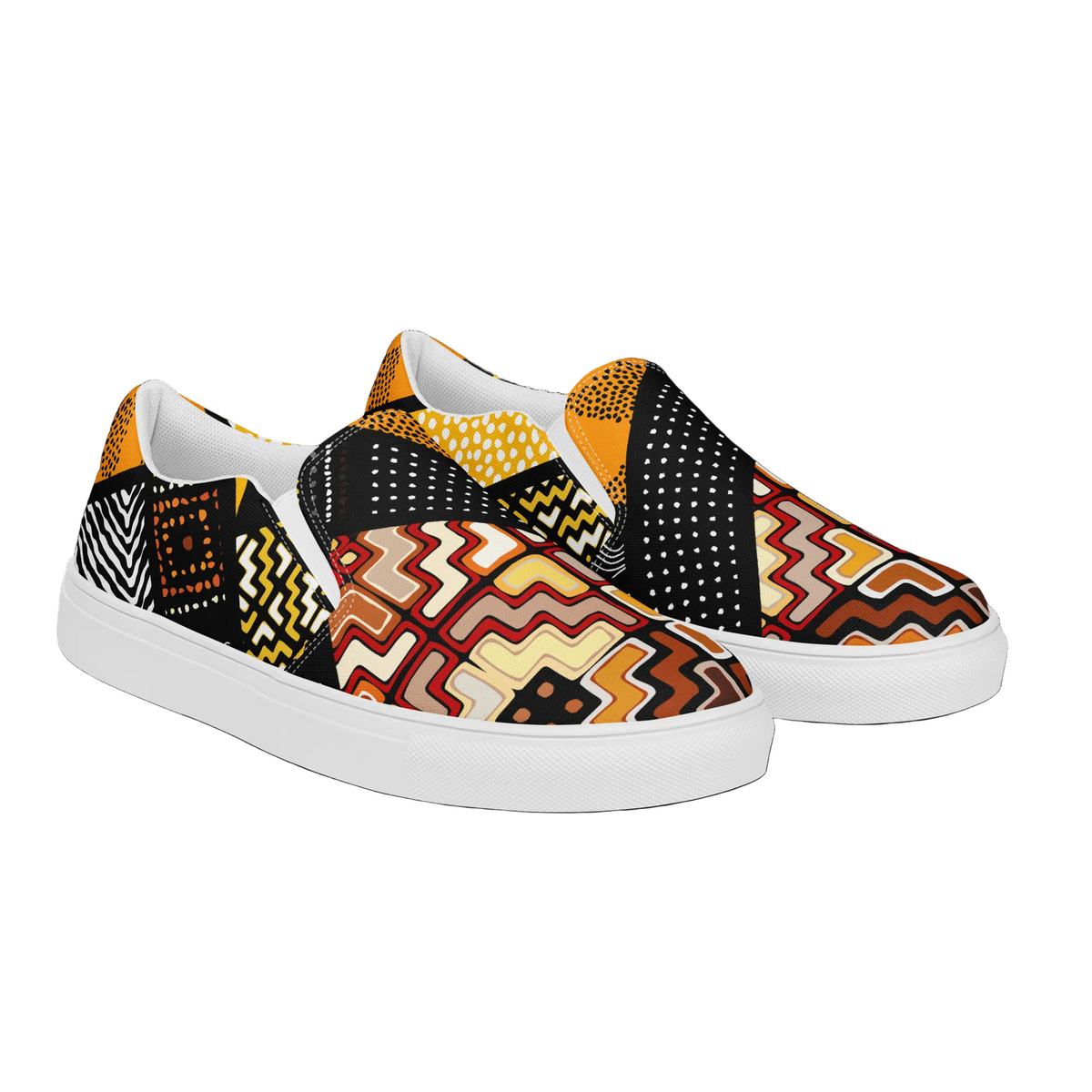 A pair of slip-on canvas sneakers with a vibrant, multicolor geometric and tribal-inspired pattern featuring zigzags, dots, and stripes in black, yellow, orange, red, and white, set against a plain white background.
